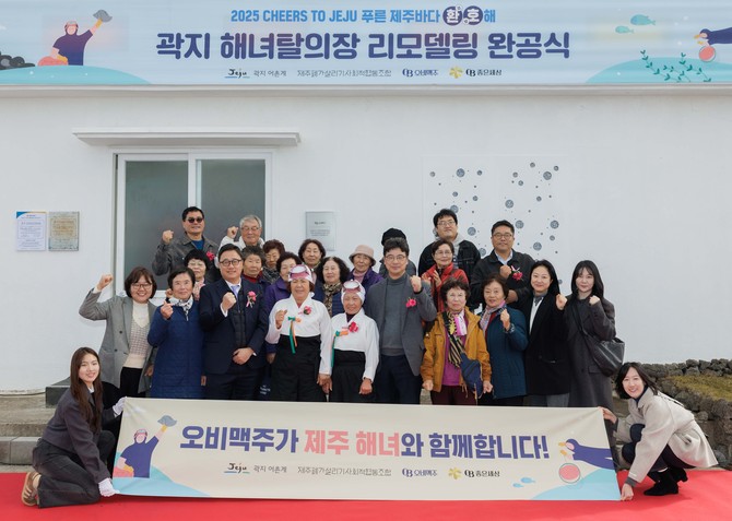 제주시 애월읍 곽지리 해녀탈의장 앞에서 해녀 및 지역 주민과 기념사진을 촬영하는 모습. ⓒ 오비맥주