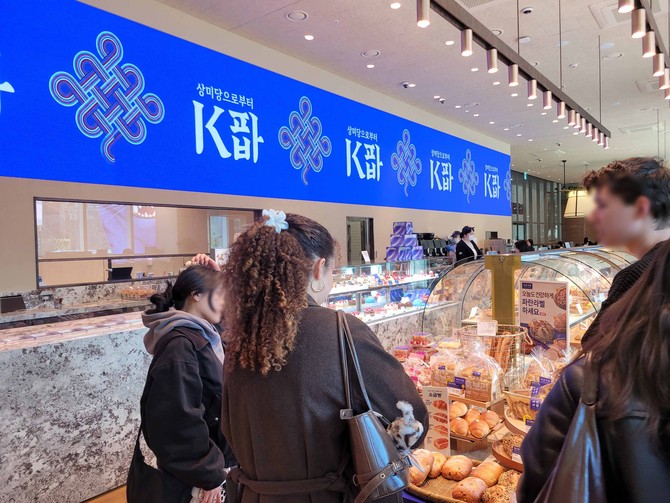 지난 19일 서울 종로구에 위치한 파리바게뜨 광화문 1945점을 찾은 외국인들이 ‘K파바’ 비전이 적용된 특화 제품를 구경하는 모습. ⓒ 파리바게뜨