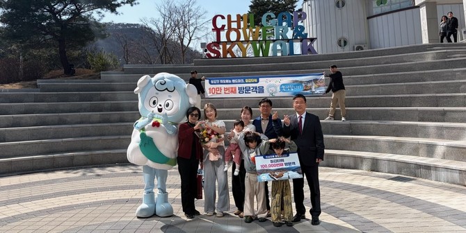 지난 22일 청양 칠갑타워에서 열린 10만 방문객 돌파 기념 이벤트에서 강희선 관광진흥과장(오른쪽 끝)이 10만번째 방문객 임연옥 씨(왼쪽에서 다섯번째)에게 기념품을 전달 후 기념촬영을 하고 있다. ⓒ 청양군