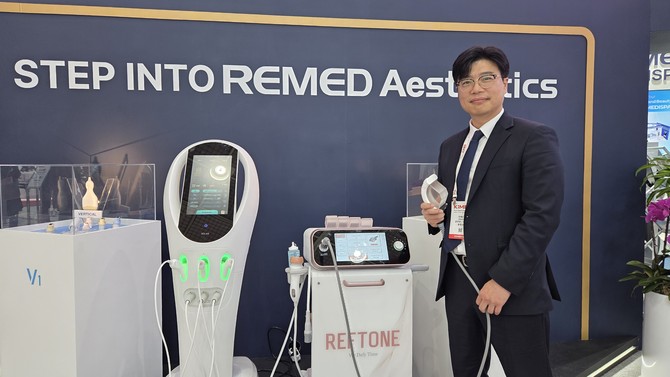 송종은 리메드 영업본부장이 지난 22일 코엑스 'KIMES 2026' 현장에서 프리미엄 재생리프팅 의료기기 '레프톤'과 함께 사진 촬영을 진행 중인 모습. = 박기훈 기자