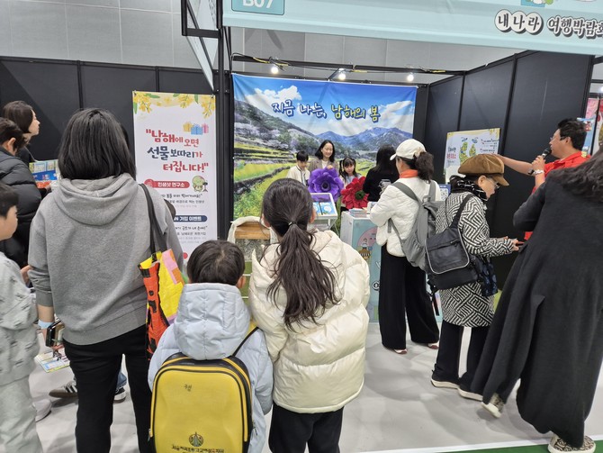 서울 코엑스 마곡에서 열린 '2026 내나라 여행박람회'에서 방문객들이 남해관광문화재단이 마련한 두모마을 유채꽃밭 포토존에서 사진을 찍고 있다. ⓒ 남해군