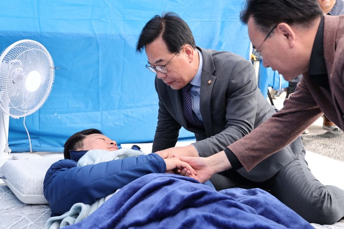 송언석 국민의힘 원내대표·유상범 원내운영수석부대표가 22일 국회 본청 앞에서 단식 12일 차를 맞은 안호영 의원의 천막 농성장을 찾아 대화하고 있다. ⓒ 연합뉴스