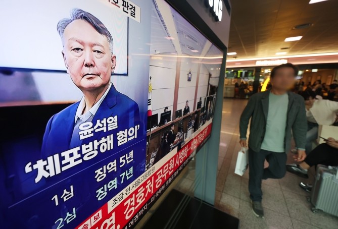 고위공직자범죄수사처(공수처) 체포 방해 등 혐의로 기소된 윤석열 전 대통령의 항소심 선고 공판 생중계 방송이 29일 서울역 대합실에서 TV를 통해 송출되고 있다. ⓒ 연합뉴스