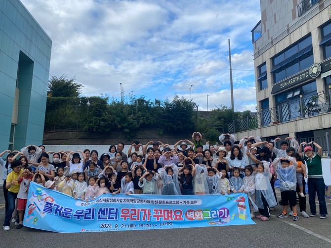 합천군이 가족과 함께하는 예술의 시간, 육아지원센터 벽화 그리기를 하고 기념촬영을 하고 있다. ⓒ 합천군