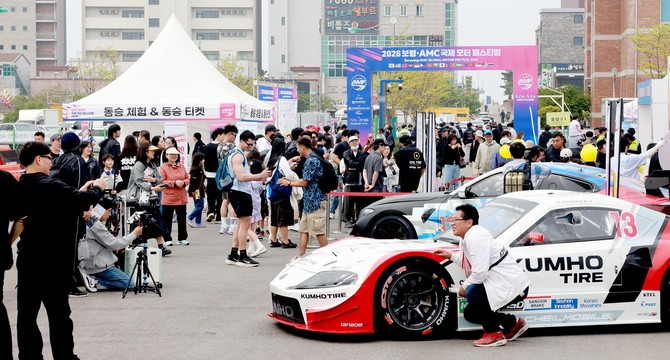 보령시 보령머드엑스포광장에서 열린 '2026 보령 AMC 국제 모터 페스티벌'에서 관람객들이 레이싱 차량 전시와 동승 체험 부스 앞에 몰려 축제를 즐기고 있다. ⓒ 프라임경제