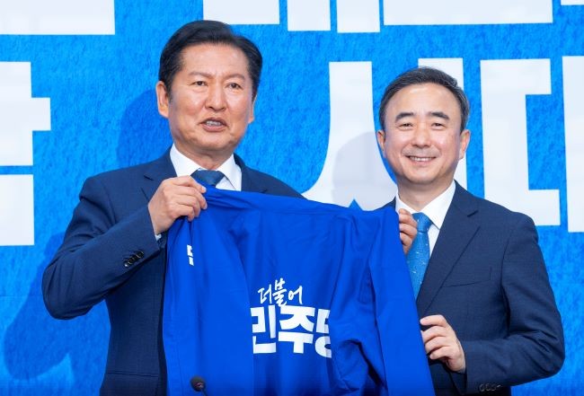 6·3 재보선에서 더불어민주당 후보로 광주광역시 광산을 선거구에 공천이 유력한 임문영 AI전략위원회 상근부위원장(오른쪽)이 6일 국회에서 열린 더불어민주당 인재 영입식에서 정청래 대표에게 민주당 상징인 '파란 점퍼'를 전달받고 있다. ⓒ 연합뉴스