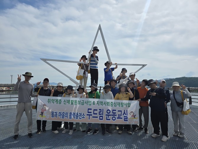 고성군이 관내 시설에 거주하는 장애인 20명을 대상으로 상족암 일원에서 '해양치유길 연계 야외수업'을 실시하고 기념촬영을 하고 있다. ⓒ 고성군