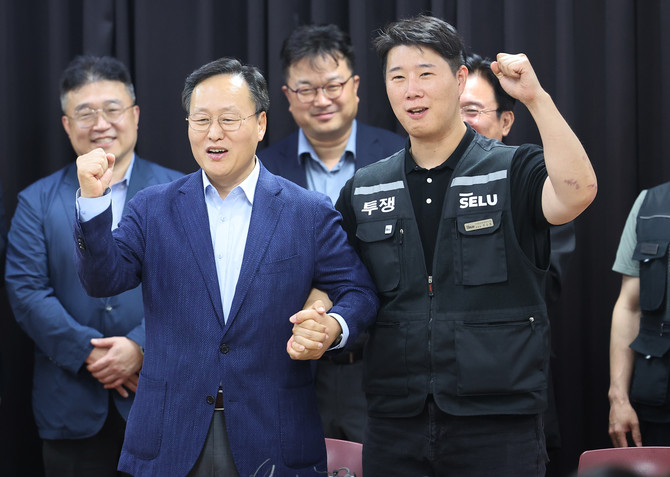 지난 20일 경기도 수원시 장안구 경기고용노동청에서 열린 삼성전자 임금협상을 마친 후 여명구 삼성전자 DS 피플팀장과 최승호 삼성그룹 초기업노동조합 삼성전자지부 위원장이 잠정 합의안에 서명한 후 파이팅을 외치고 있다. ⓒ 연합뉴스