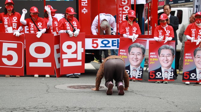 의령군에 거주하는 어머니께서 예상치도 못하게 그동안 의령발전을 위해 노력한 오태완 의령군수에게 기호 5번 큰절을 다섯번 올리고 있다. 이에 오 군수도 큰절로 보답하며 1500여명의 지지자들도 존경과 사랑이 담긴 큰 박수로 화답하고 있다. = 강경우 기자