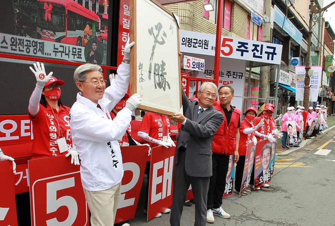 전임수 전 의령군의회 의장께서 손수 묵필한 필승 서화를 전달하고 있다. = 강경우 기자