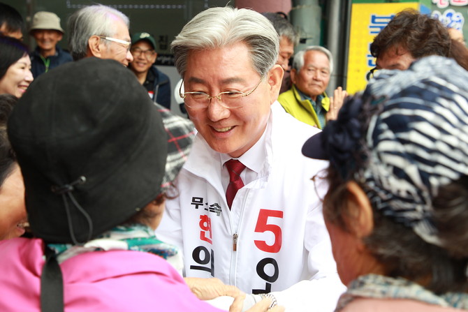 오태완 의령군수가 출정식에서 지지자들과 눈 높이를 같이하고 있다. = 강경우 기자