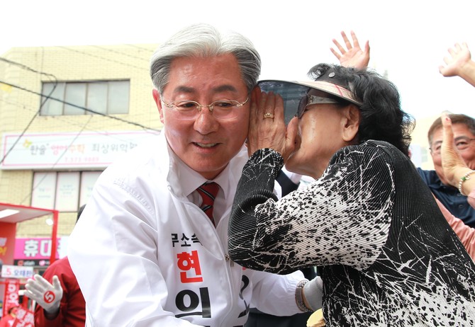 의령 군민이 오태완 후보에게 귓속말로 애로사항을 이야기하고 있다. = 강경우 기자