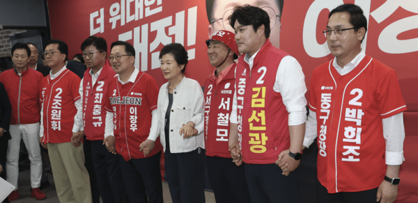 박근혜 전 대통령이 25일 국민의힘 이장우 대전시장 후보 대전 중구 선거사무실을 찾아 방문 배경을 밝힌 뒤 이장우 후보와 대전지역 5개 구청장 후보들과 손을 맞잡고 있다. =오영태 기자