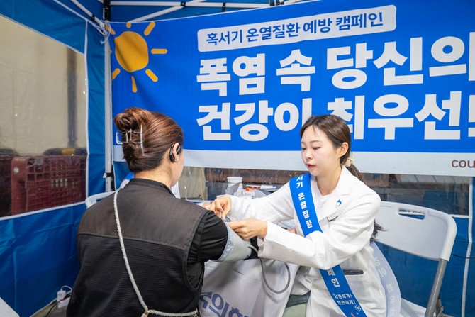KMI 의료진이 일산1캠프에 입차한 위탁배송기사의 혈압을 측정하고 있다. ⓒ 쿠팡