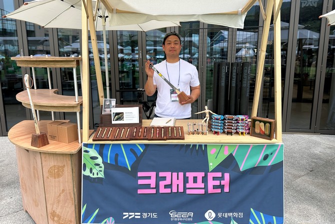 롯데프리미엄아울렛 의왕점 잔디광장에서 진행하는 '2026 업사이클 팝업스토어'에서 참여자들이 행사를 홍보하고 있다. ⓒ 롯데백화점