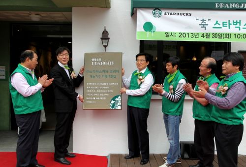  이석구 스타벅스 대표(왼쪽에서 세번째)와 권승 전포종합사회복지관장(왼쪽에서 두번째), 스타벅스 협력사 대표들이 재단장 오픈한 부산 전포종합사회복지관의 빵카페 '빵집'  완공 기념 현판식을 진행하고 있다. ⓒ 스타벅스