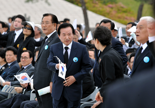  국립 5.18묘지에서 열린 제33주년 5.18 민주화운동 기념식에서 ‘임을 위한 행진곡’ 합창공연이 시작되자 강운태 광주시장이 박근혜 대통령에게 태극기를 건네고 있다.ⓒ광주광역시