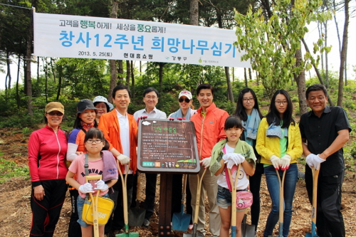 창립 12주년을 맞은 현대홈쇼핑은 25일 강동구 명일동 훼손된 산림지역에 '4000 그루 희망나무심기' 행사를 진행했다. 김인권 현대홈쇼핑 대표(사진 표지판 좌측)와 이해식 강동구청장(사진 표지판 우측)을 비롯해 현대백화점 천호점 고객들과 자녀들이 기념 촬영을 하고 있다. ⓒ 현대홈쇼핑