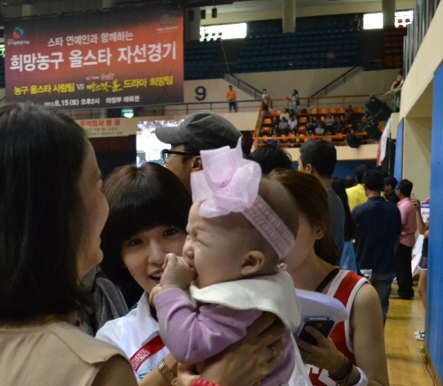 연기자 정인선이 자선농구경기 현장을 찾았다가 시민이 안고 있는 아기를 보고 있다. ⓒ 프라임경제