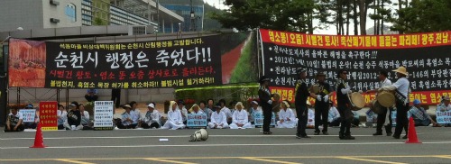 순천 석동마을 어르신들이 흰 소복을 입고, 차가운 아스팔트에 앉아 흑염소 농장의 불법행위에 대한 대책마련을 요구하고 있다. = 장철호 기자