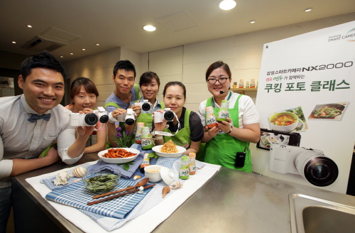  삼성전자가 11일 서울 충무로 샘표 지미원에서 발효 전문 기업 샘표와 함께 사진과 요리에 관심이 많은 주부 고객들을 대상으로 '푸드 포토 쿠킹클래스' 행사를 진행했다. 요리 블로거 미상유(사진 가장 왼쪽)와 참가자들이 NX2000과 '푸드 포토 쿠킹클래스'를 소개하고 있다. ⓒ 삼성전자