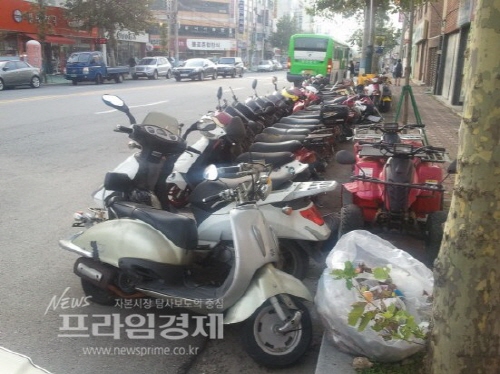  수 년째 도로와 인도를 점령해 버스승객과 행인들의 안전을 위협하고 있는 오토바이들. 사진=나광운기자