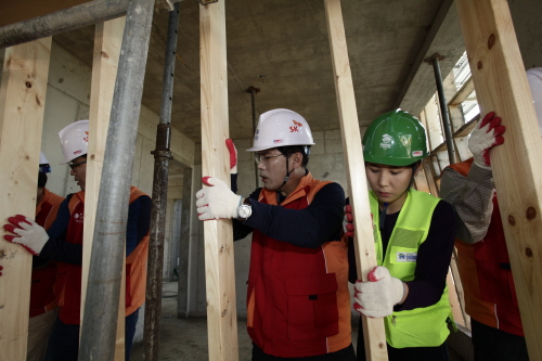  안승윤 SK브로드밴드 사장(오른쪽에서 세번째) 과 임직원들이 함께 수원시 권선동에서  저소득 무주택가정을 위해 집짓기 봉사활동을 펼치고 있다. ⓒ SK브로드밴드