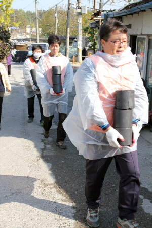  지난 26일 호반건설 봉사단 호반사랑 나눔이 50여명이 구룡마을 소외계층에 연탄을 배달하고 있다. ⓒ 호반건설