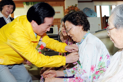  광주는 여성과 노인이 행복한 도시, 장애인이 차별받지 않는 도시로서의 위상을 날로 강화해 가고 있다. 사진은 강운태 광주광역시장이 어르신들에게 꽃을 달아주는 모습. ⓒ 프라임경제