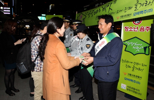  최수만 오비맥주 정책홍보 부사장과 건전음주문화 봉사단원이 서울 강남역 일대에서 수능 시험을 마친 수험생들에게 '당당해야 제 맛, 청소년이여 성년이 되어 진짜 즐겨라!'등 음주예방 문구가 새겨진 홍보물을 나눠주며 올바른 음주문화의 중요성을 알리고 있다. ⓒ 오비맥주