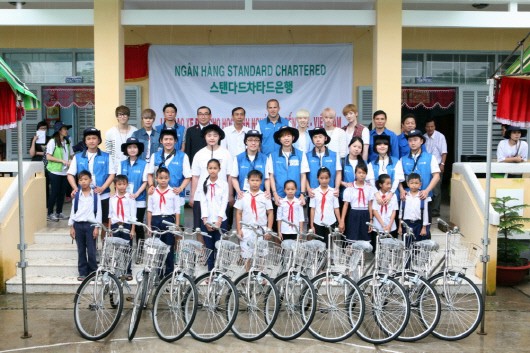 해외봉사단 '아이캠프(Eye Camp) 원정대'가 지난 15일 베트남 벤쩨성 초등학교에서 저소득층 학생들에게 자전거를 기증했다. 기증식 후 SC은행 임직원과 현지 학생들이 기념촬영을 하고 있다. ⓒ SC은행
