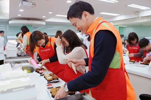  현대건설 임직원들로 구성된 봉사자들과 사랑나눔 도시락 지원을 받게 된 아이들이 지난 27일 사랑의 컵케잌과 쿠키를 만들며 즐거운 시간을 보내고 있다. ⓒ 현대건설