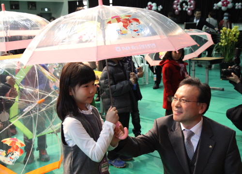  3월3일 서울 서대문구 미동초등학교에서 고광환 NH농협생명 경영지원본부장이 1학년 새내기 초등학생에게 투명우산을 전달하고 있다. ⓒ NH농협생명
