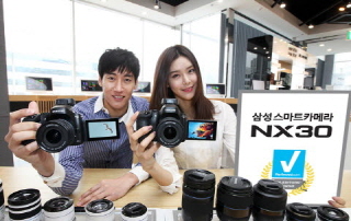 삼성전자 모델들이 2월 국내에 출시한 프리미엄 미러리스 스마트카메라 'NX30'을 선보이고 있다. ⓒ삼성전자