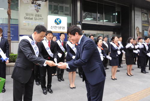  이성락 신한생명 사장(왼쪽)이 3일 서울 청계천로 본사 앞에서 진행된 봄맞이 가두 캠페인에 참여해 행인들에게 꽃씨를 나눠주고 있다. ⓒ 신한생명