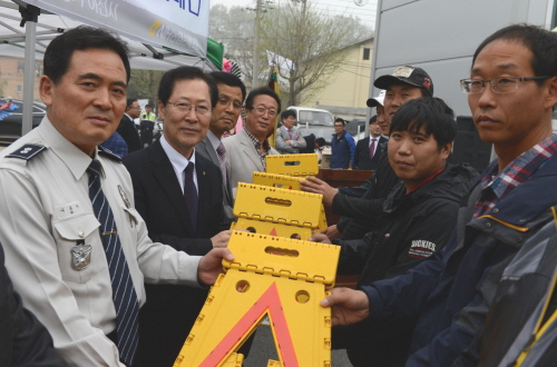  (사진 왼쪽부터) 나봉수 율면 파출소장, 김학현 NH농협손해보험 대표이사, 남기학 율면 면장 등이 농기계 운전자에게 안전 삼각대를 전달하고 있다. ⓒ NH농협손해보험