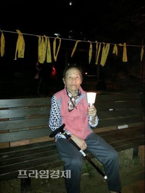  82세의 할머니가 세월호 실종자들의 무사생환을 바라는 간절한 마음으로 노란리본 밑에서 촛불을 들고 있다. ⓒ나광운기자