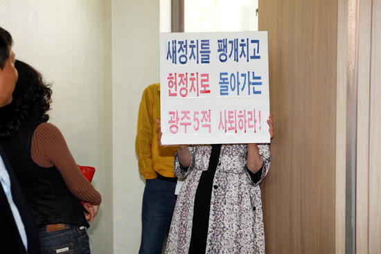  이용섭 의원 지지자로 보이는 여성당원이 회의장 입구에서 &lsquo;새정치를 팽개치고 헌 정치로 돌아가려는 광주5적 사퇴하라&rsquo;는 푯말을 들고 항의하고 있다.=김성태 기자