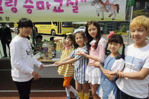  홀트학교 어린이 홍보대사가 한 장애아동에게 사인 CD를 전달하고 있는 모습. = 김경태 기자