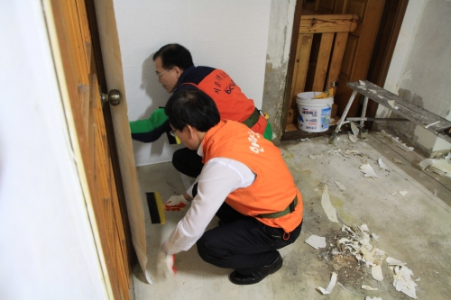  ㈜한화 이성규 전무(사진 왼쪽), 안중현 서울지방보훈청장(사진 오른쪽)이 함께 '2014 나라사랑 클린하우스' 사업에 동참, 도배 작업을 돕고 있다. ⓒ (주)한화