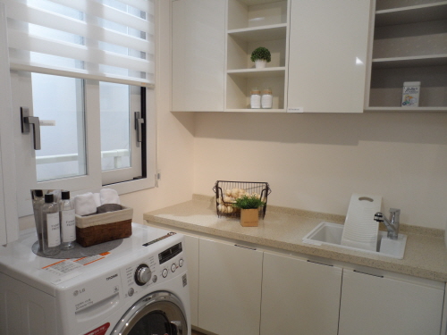  주부의 마음을 헤아린 세탁실은 세탁기를 놓고도 미니건조대를 설치할 수 있을 만큼 널찍했다. 여기에 손빨래를 위한 입식 보조 작업대와 세탁용품을 진열할 수 있는 수납장까지 있어 편의를 배가시켰다. = 박지영 기자