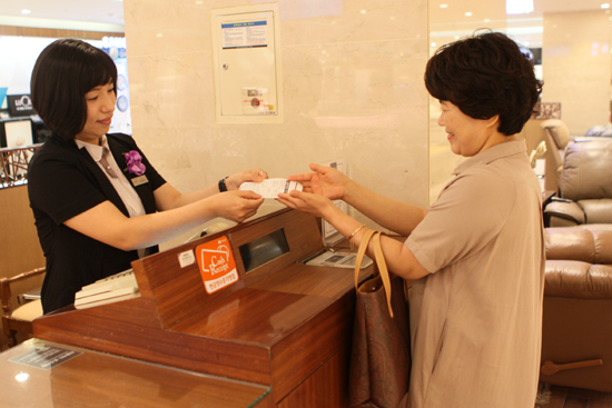  18일 롯데백화점 광주점을 찾은 고객이 상품 구입 후 비스페놀 물질이 전혀 포함되어 있지 않은 친환경 영수증 용지를 건네 받고 있다. ⓒ롯데백화점 광주점