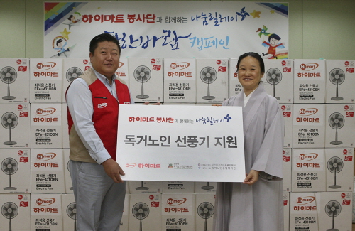  김세완 롯데하이마트 본부장(사진 왼쪽)이 소지 강북노인종합복지관 관장 스님(사진 오른쪽)에게 폭염대비 선풍기를 전달하고 기념 촬영을 하고 있다. ⓒ 롯데하이마트