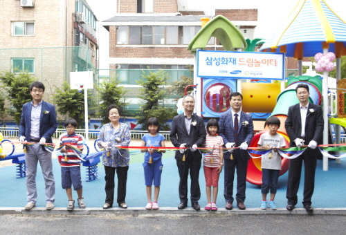  삼성화재 및 강동꿈마을 관계자, 원아들이 놀이터 개관 커팅식을 진행하고 있다. ⓒ 삼성화재
