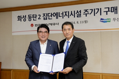  한기선 두산중공업 사장(오른쪽)과 김성회 한국지역난방공사 사장(왼쪽)이 11일, 경기도 분당 한국지역난방공사 본사에서 화성 동탄2 집단에너지시설 공사 수주계약을 체결하고 기념촬영을 하고 있다. ⓒ 두산중공업