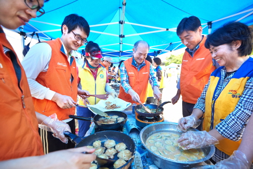  정연대 코스콤 사장이 임직원, 지역주민들과 함께 전을 부치고 있다. ⓒ 코스콤