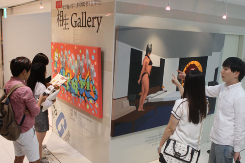  롯데백화점 광주점을 찾은 고객들이 엘리베이터 홀에 마련된 지역 청년 작가들의 작품을 감상하고 있다.ⓒ롯데백화점 광주점