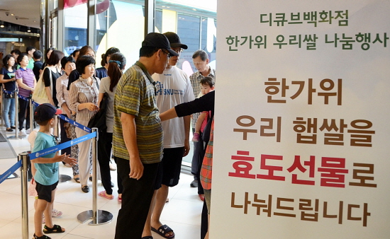  6일 오전 신도림 디큐브백화점 지하1층 영스트리트 행사장에서 임직원과 도우미들이 부모님과 함께 방문한 고객들에게 햅쌀을 나눠주고 있다. 디큐브백화점은 추석을 맞아 부모님과 함께 방문한 고객 총 2000명에게 햅쌀 2kg씩 총 4톤을 무료 증정하는 행사를 마련했다. 이날 오전 11시부터 진행된 행사에 고객들이 줄을 잇는 등 호응이 뜨거웠다. ⓒ 디큐브백화점